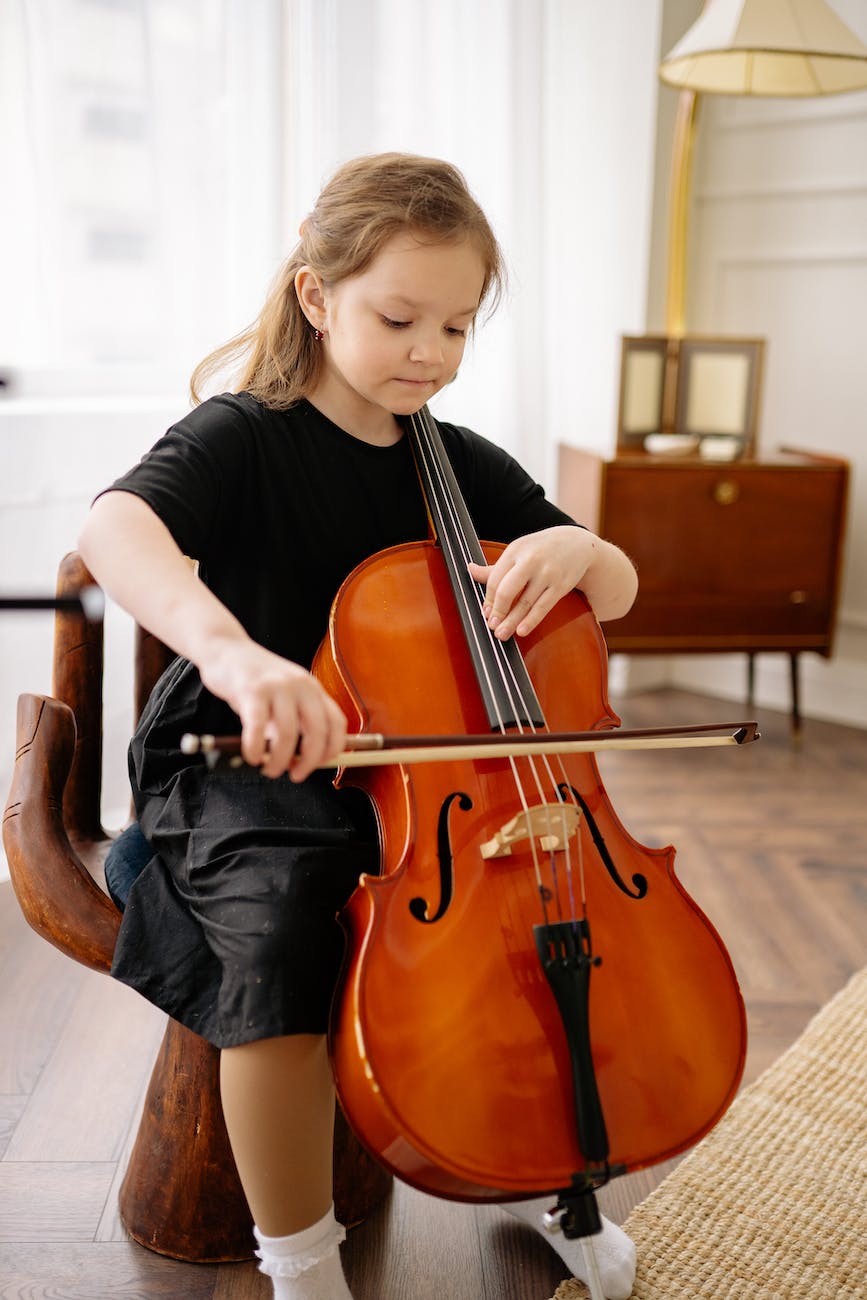 a girl in black dress playing cello